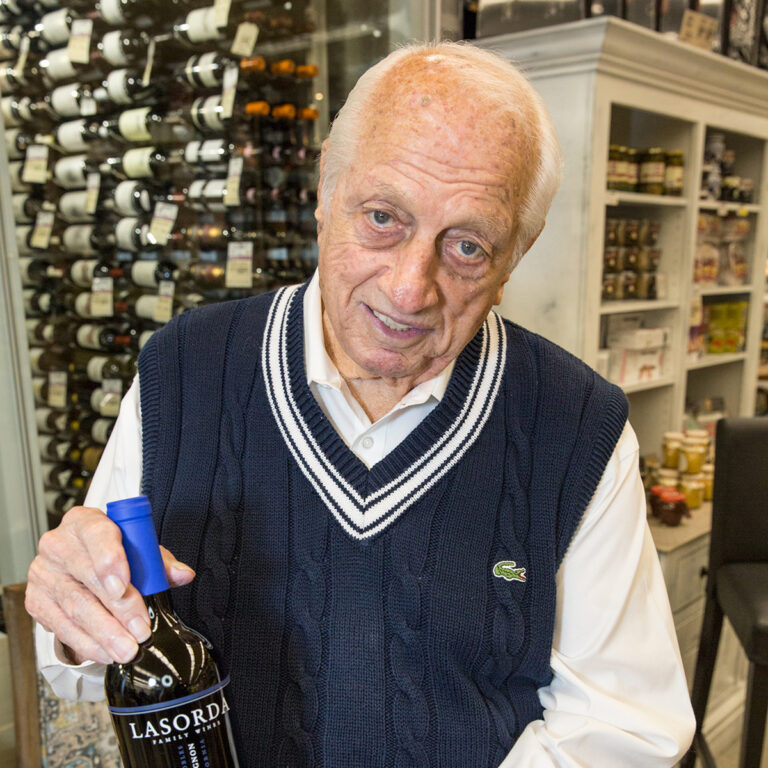 A man holding a bottle of wine in his hand.