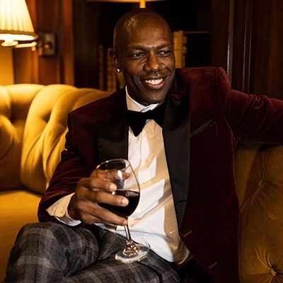 A man sitting on the couch holding a glass of wine.